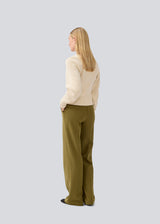 Fitted knit in organiccotton. GalenMD short v-neck is in a creme color, has long vide sleeves and a v-neck. The model is 177 cm and wears a size S/36.