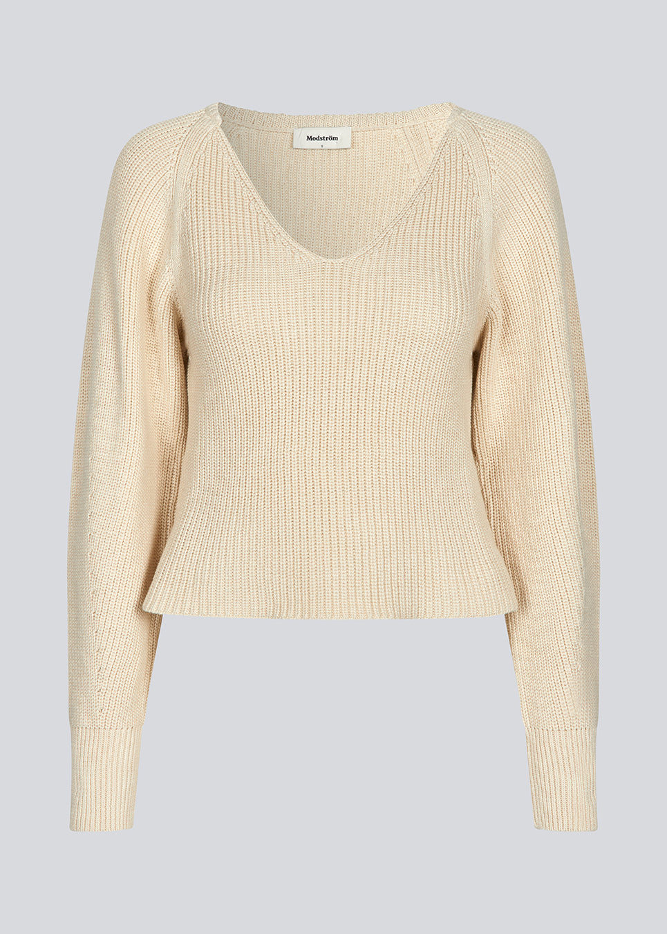 Fitted knit in organiccotton. GalenMD short v-neck is in a creme color, has long vide sleeves and a v-neck. The model is 177 cm and wears a size S/36.