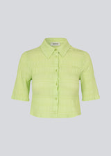 Cropped shirt in a structured woven quality with a regular fit. HamsonMD shirt has a collar, button closure in front, and short sleeves. The model is 175 cm and wears a size S/36.