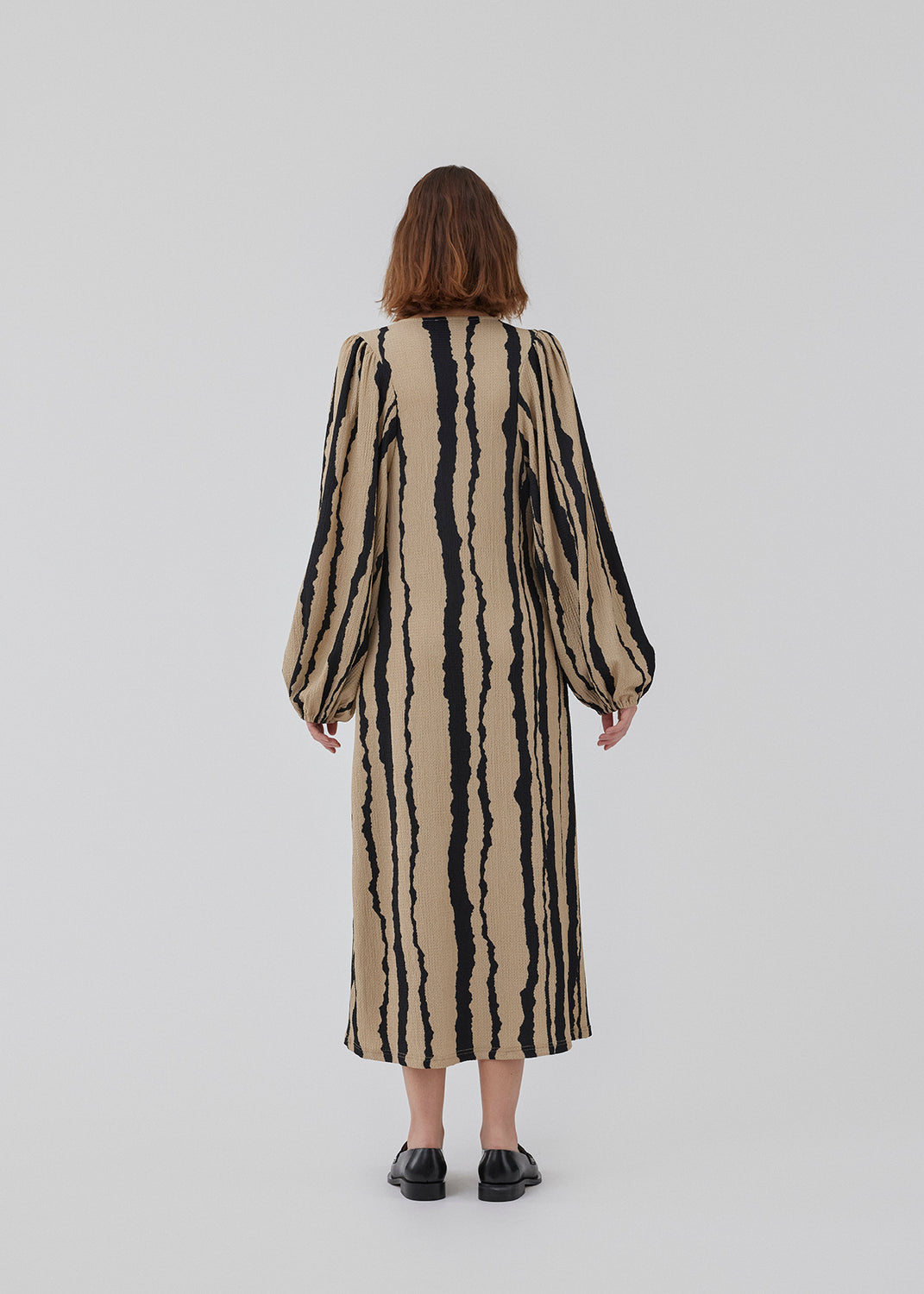 Printed midi dress with a v-neckline and long balloon sleeves with elastic. HarlandMD print dress has a loose silhouette. The model is 175 cm and wears a size S/36.