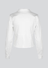 Form-fitting shirt in white in a woven cotton blend with collar, buttons in front, and long sleeves with cuff. HarrisonMD shirt has darts and a cutline below the chest for a corset-inspired look. The model is 175 cm and wears a size S/36.