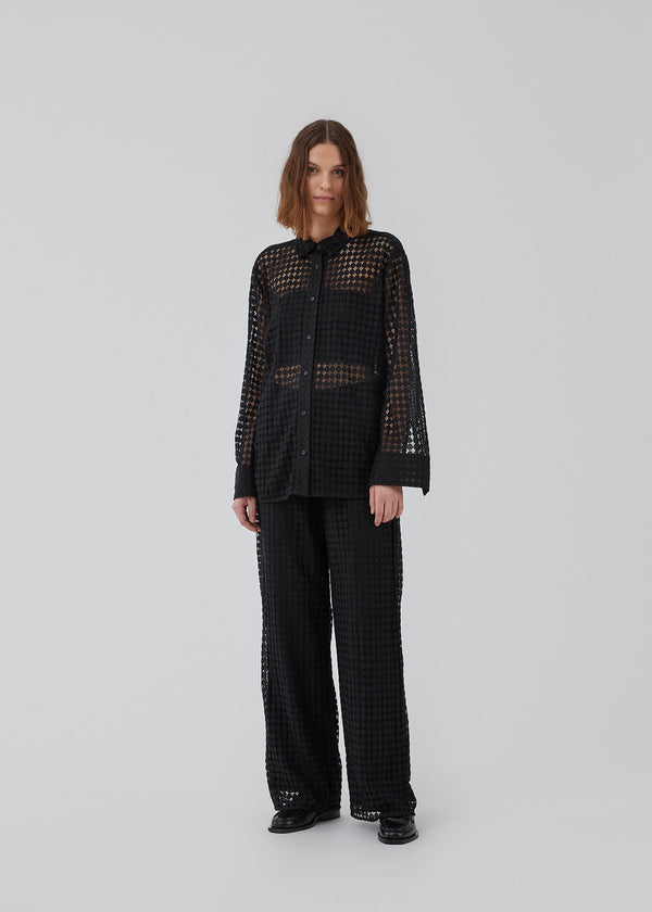 HattieMD pants in black are made from a transparent lace material. The pants have a loose fit with straight legs and a medium elasticated waist. Lined. The model is 175 cm and wears a size S/36.