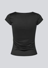Fitted black T-shirt with draping. The Himamd Drapy T-shirt is made from 95% recycled polyester and features an elastic fit. The sophisticated draping adds a feminine and modern twist, perfect for both everyday and evening looks. 