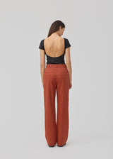 Black t-shirt with a deep back and short sleeves in an elastic material. HimaMD t-shirt is fitted and has a deep back neckline. The model is 175 and wears a size S/36.