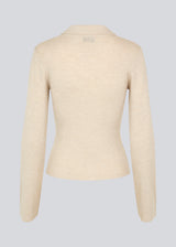 Fitted cardigan in beige made from a soft, rib-knitted wool. HirokiMD cardigan has a collar, buttons in front, and long sleeves with slit and buttons. The model is 175 cm and wears a size S/36.