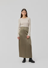 Fitted off white top made in a soft, rib-knitted wool. HirokiMD o-neck has long flared sleeves. The model is 175 and wears a size S/36.
