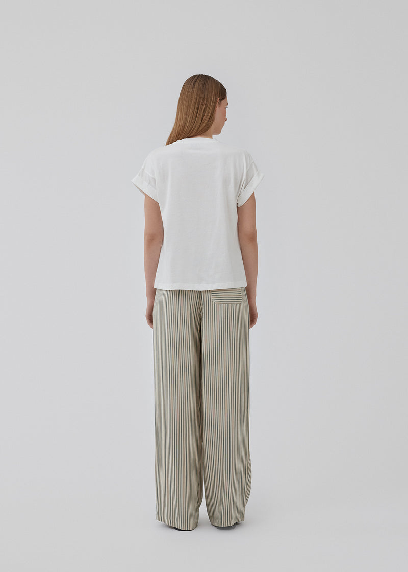 Pants with a relaxed shape. HissaMD print pants has wide legs and a high waist with covered elastication and tiebands. Side pockets and a patch back pocket. The model is 175 cm and wears a size S/36.