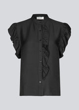 HolidayMD top in black is designed with a standing collar and button closure in front. The top has a frilly detail along the placket and at the armholes. 