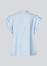 HolidayMD top in light blue is designed with a standing collar and button closure in front. The top has a frilly detail along the placket and at the armholes. The model is 175 cm and wears a size S/36.