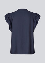 HolidayMD top in navy blue is designed with a standing collar and button closure in front. The top has a frilly detail along the placket and at the armholes. 