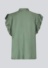 HolidayMD top in soft green is designed with a standing collar and button closure in front. The top has a frilly detail along the placket and at the armholes. 