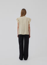 HolidayMD top in bright beige is designed with a standing collar and button closure in front. The top has a frilly detail along the placket and at the armholes. The model is 175 cm and wears a size S/36.