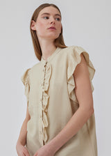 HolidayMD top in bright beige is designed with a standing collar and button closure in front. The top has a frilly detail along the placket and at the armholes. The model is 175 cm and wears a size S/36.