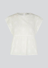Top in white in broderie anglaise cotton with cutline below the chest with extra volume. HollynMD top has a round neck, short sleeves, and a small opening at the neck with button closure. The model is 175 cm and wears a size S/36.