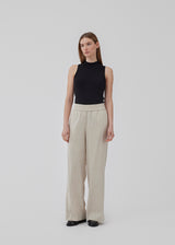 Pants in beige designed with a casual look and fit in a cotton and linen blend. HonorMD pants has loose legs and a medium waist with a wide elastic band. The model is 175 cm and wears a size S/36.