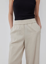 Pants in beige designed with a casual look and fit in a cotton and linen blend. HonorMD pants has loose legs and a medium waist with a wide elastic band. The model is 175 cm and wears a size S/36.
