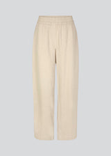 Pants in beige designed with a casual look and fit in a cotton and linen blend. HonorMD pants has loose legs and a medium waist with a wide elastic band. The model is 175 cm and wears a size S/36.