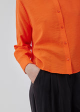 Shirt in bright red a light EcoVero viscose with a loose fit. HudgesMD shirt has a collar, button closure in front, and long sleeves with cuff. The model is 175 cm and wears a size S/36.