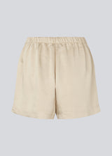 Lose beige shorts in satin with an elastic waist. IolaMD shorts has a medium high waist and side pockets. The model is 177 cm and wears a size S/36.
