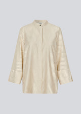 Shirt with copped sleeves and a slit. IsabelMD shirt has a hidden button closure and a high neck.