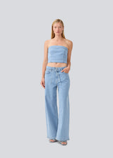 Short denim top in a corset design. IvannaMD top in made in light colored denim and is closed with a zipper at the back.