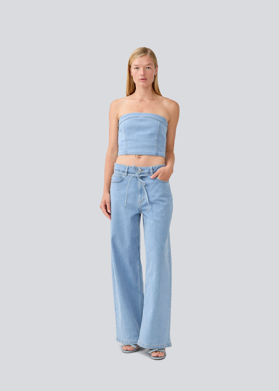 Short denim top in a corset design. IvannaMD top in made in light colored denim and is closed with a zipper at the back.