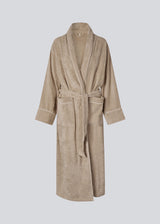 Beige oversized bathrobe. Josefinemd bathrobe is made from 100% organic cotton. It features large pockets, a belt, and contrast trims for an elegant touch. Finished with a subtle logo on the back – ideal for cozy mornings. Josefine Vogt (165 cm) and the model (177 cm) are both wearing size Small.