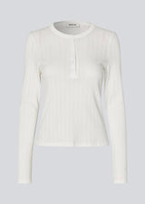 White fitted long-sleeve pointelle t-shirt. Josefinemd LS t-shirt is crafted in pointelle cotton with lace trim. The feminine cut and subtle openwork pattern give this classic style an elegant touch. Josefine Vogt (165 cm) and the model (177 cm) are both wearing size Small.
Shop matching pants: Josefinemd pants 