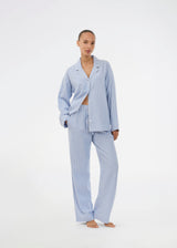 Blue classic striped pyjamas. The pyjamas is sold as a set of shirt and pants in the same size. Josefinemd pyjamas are made from 100% soft cotton and feature a classic fit with a collar, button closure, and drawstring trousers. Finished with delicate wave trim and comes with a matching pouch with logo. Josefine Vogt (165 cm) and the model (177 cm) are both wearing size Small.