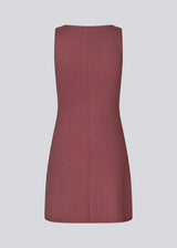 Fitted mini dress in burgundy/red in an A-line shape with a round neck and no sleeves. JosefineMD tank flare dress is made from a stretchy material. 
Fit: Designed for a tight, fitted silhouette with 90's inspiration.
Sizing: Runs small – consider sizing up for a looser fit.
Silhouette: A-line shape for a subtle flare and flattering finish.
Design: Sleeveless with a round neckline for a minimalist, chic look.
Material: Made from stretchy fabric, ensuring comfort and flexibility.
Model: Josefine Vogt i