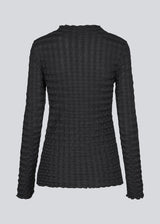 Black top with long sleeves in structured jersey. KimoraMD LS top is fitted and has a high neck. The model is 175 cm and wears a size S/36.