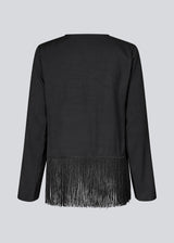 Black top with long sleeves in twill and a fringe detail. KylerMD shirt has a V-neck and loose sleeves.