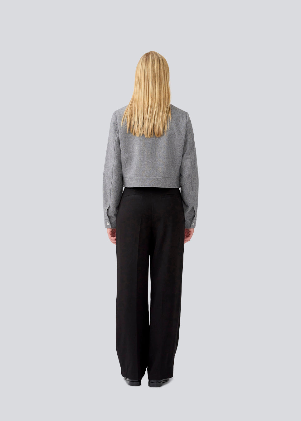 Cropped grey jacket in 80% wool. LissieMD jacket has a classic collar, manchet with button closure and a zipper in front. The model is 177 cm and wears a size S/36.