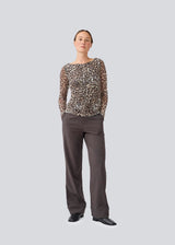 GwenMD top is a tight-fitted mesh top in leo print and gatherings in front. The top has a wide neckline and long sleeves, that are slightly more transparent than the body. 