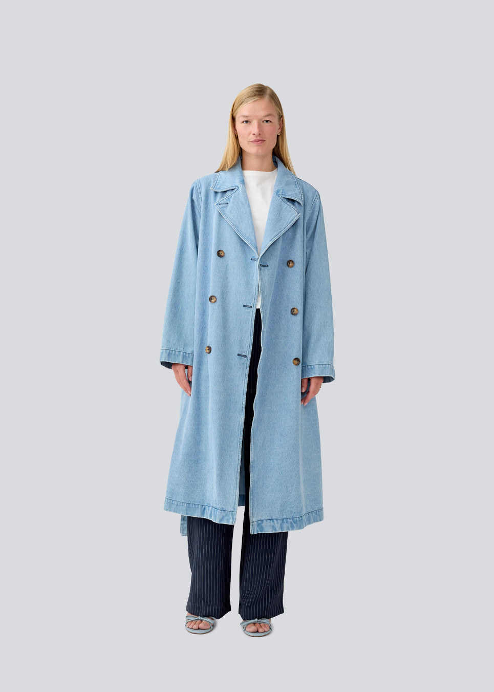 Oversized double-breasted trench coat in denim. MadelineMD denim jacket has dropped shoulders, long wide sleeves and a tieband at the waist.