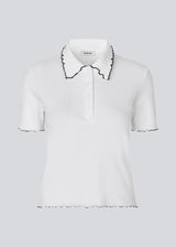 Fitted polo t-shirt in white with black edges in jersey. MagdaloneMD polo has short sleeves and babylock edges. The model is 177 cm and wears a size S/36