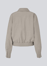Short jacket with elasic in the buttom. MaggieMD jacket has a collar, zipper closure and sidepockets.