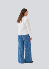 Longsleeved shirt with a wrap detail. MalleMD shirt has a pocket in front, wide sleeves and is closed with a tieband in the side.