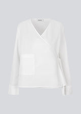Longsleeved shirt with a wrap detail. MalleMD shirt has a pocket in front, wide sleeves and is closed with a tieband in the side.