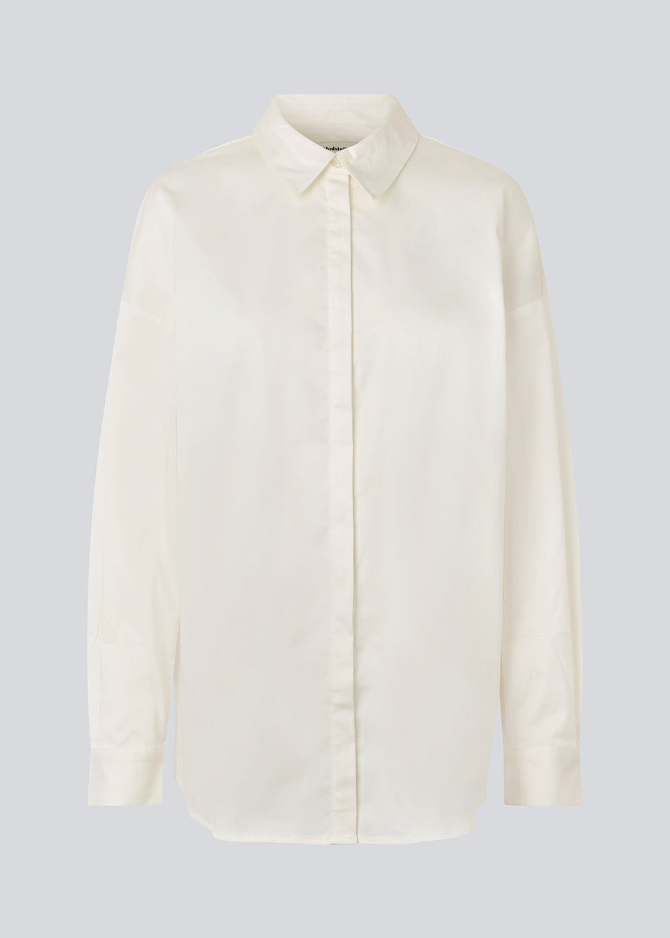 Classic shirt in white with an oversized fit. MallinMD shirt has a collar and a hidden button closure. 