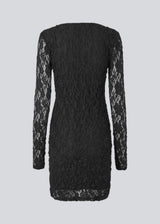 Short fitted dress in an elastic lace material. MalmunMD dress has an asymmetric neckline with an opening with button closure.