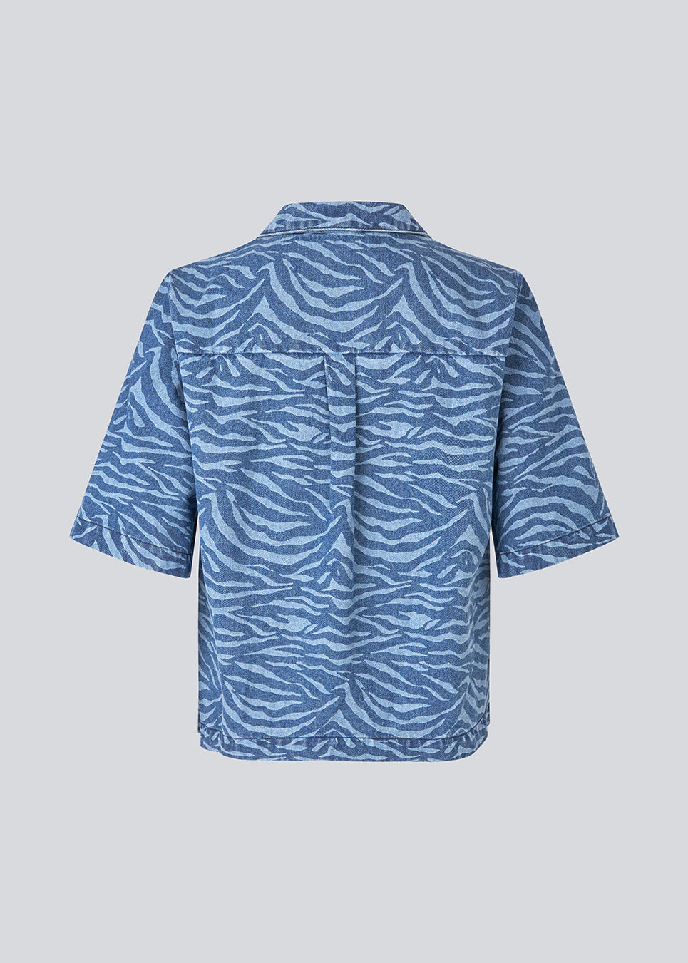 Shortsleeves shirt in denim. MaseMD print SS shirt has a loose fit, cheast pocket and a button closure in front. The model is 177 cm and wears a size S/36.