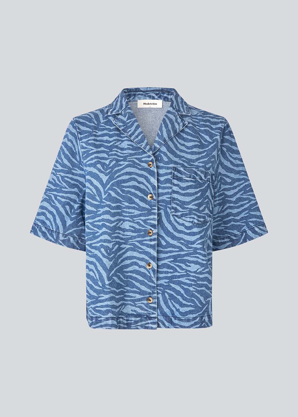 Shortsleeves shirt in denim. MaseMD print SS shirt has a loose fit, cheast pocket and a button closure in front. The model is 177 cm and wears a size S/36.