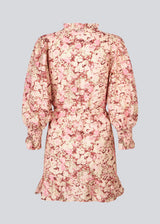 Long-sleeved dress with a v-neck and a tieband at the waist. MeliaMD print LS dress has a smock detail at the sleeves and frills. The dress has a beautiful floral print in light pink colors. The model is 177 cm and wears a size S/36.