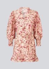 Long-sleeved dress with a v-neck and a tieband at the waist. MeliaMD print LS dress has a smock detail at the sleeves and frills. The dress has a beautiful floral print in light pink colors. The model is 177 cm and wears a size S/36.