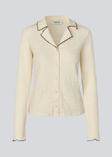 Shirt in a light and elastic material. MesiMD shirt has long sleeves, a button closure in front and babylock edges.