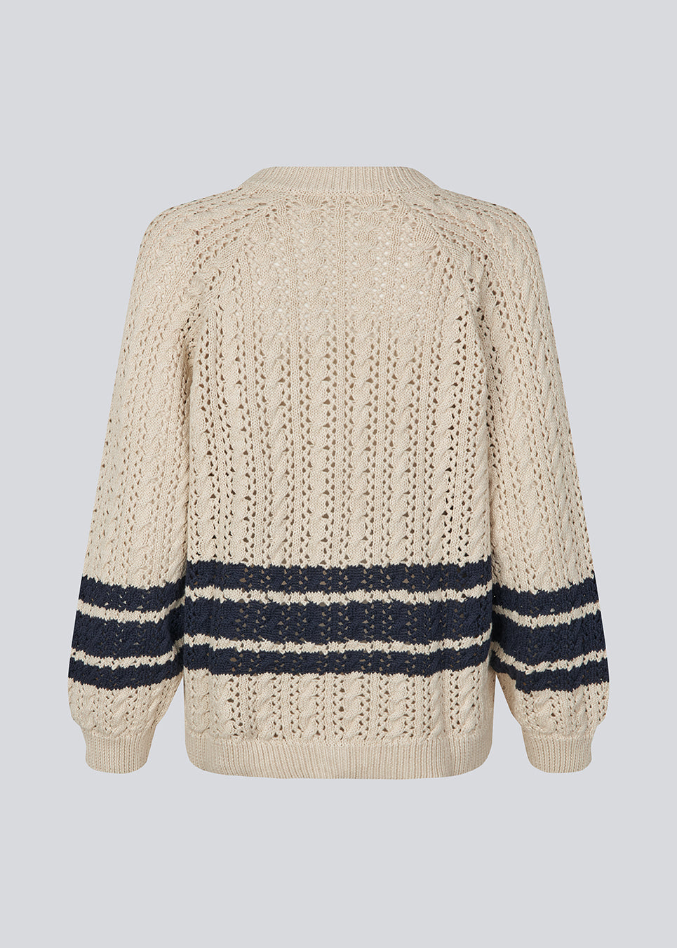 Loose knitted cardigan in beige with navy blue stripes in the button in cable knit. MetteMD cardigan is slightly see-through and has loose sleeves and a button closure. The models are 177 cm and wear a size S/36. 