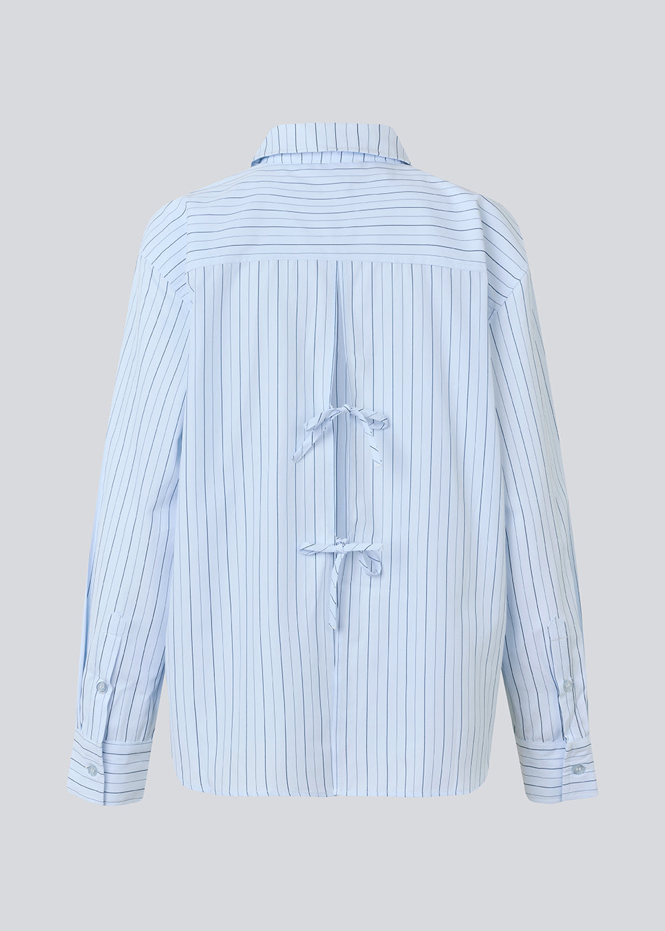 Classic shirt with an opening in the back and bow details. MilleMD stripe shirt has a oversize fit and a cuff with button closure.