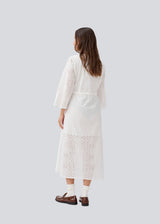 Maxi dress in broderie anglaise. MisoMD dress has a loose fit, v-neck and a tieband at the waist.