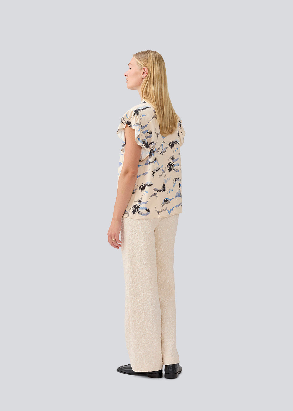 Sleeveless top with frill details. MistMD SS top has a loose fit and a button closure with frill details in front.